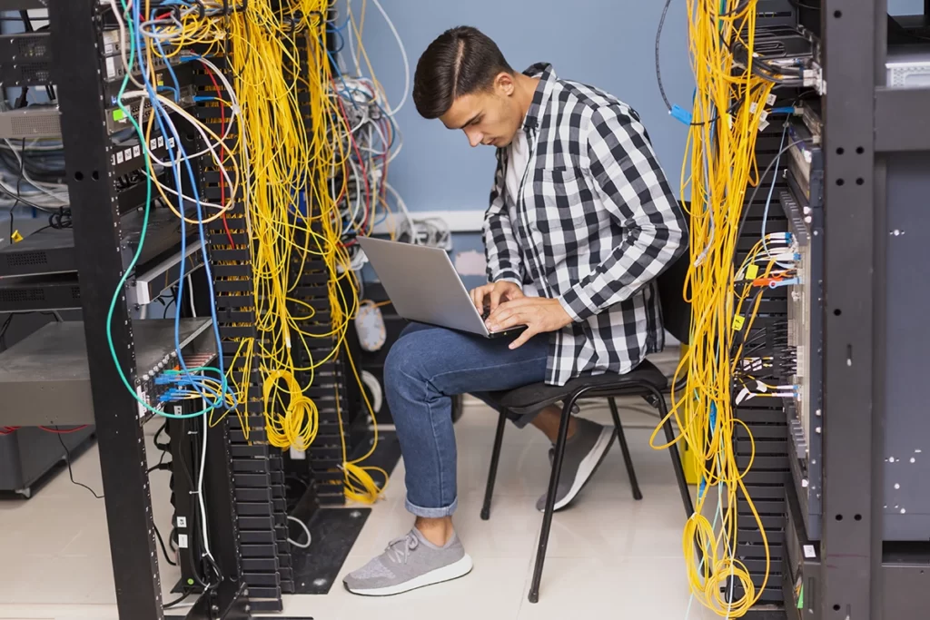 Un technicien réalise la maintenance du parc informatique 